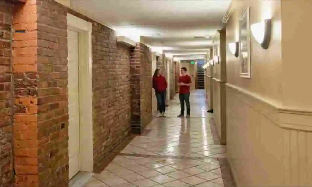 Indiana University students standing in a shared apartment or dorm hallway in Bloomington where bed bugs and apartment pest issues can spread between units.